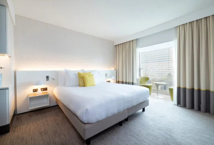 Wide view of a Deluxe room at the hotel with a bow-window lounge area, generous space and plenty of natural light.