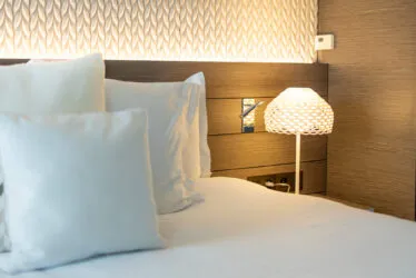 Close-up of the backlit headboard in the Saint-Antoine suite, illuminating a textured fabric wall.