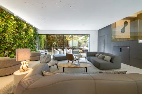 Vue d'ensemble du lobby de l'hôtel, avec canapé confortables et vue sur patio extérieur.
