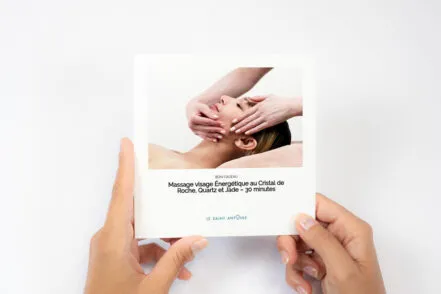Gros plan sur les mains d'une femme qui tient une carte cadeau du Saint-Antoine.