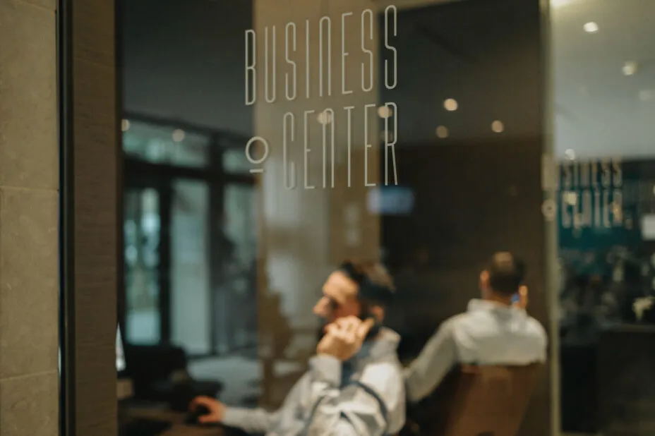 Professionnel au téléphone, isolé dans le business corner du business lounge de l’hôtel pour un travail confidentiel au calme.
