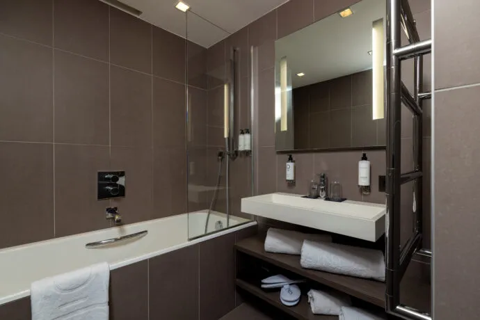 Salle de bains spacieuse et fonctionnelle d'une chambre Deluxe, avec baignoire.