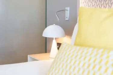 Gros plan sur les coussins et oreillers et la table de chevet d'une chambre Exécutive.