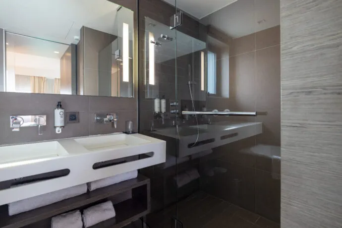 Salle de bains de la suite Saint-Antoine, avec baignoire, douche, double vasque et WC japonais.