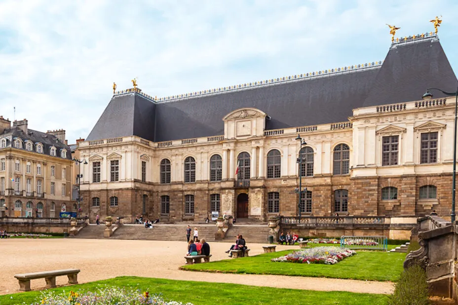 Parlement de Bretagne à Rennes, bâtiment historique imposant en pierre de taille, avec une large place piétonne et végétalisée.