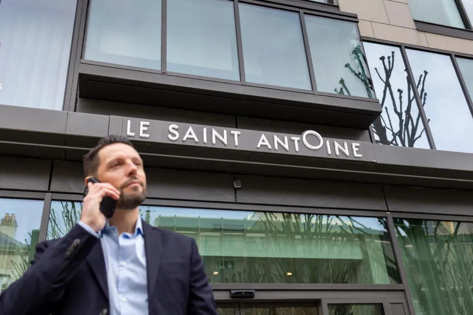 Plan en contre-plongée d’un professionnel devant l’entrée de l’hôtel.