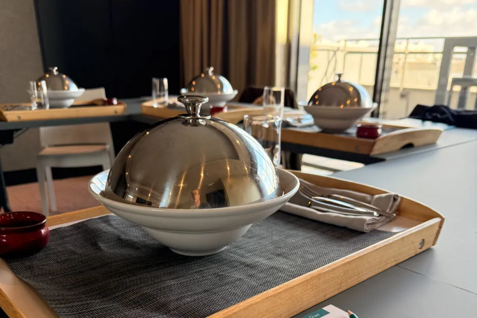 Gros plan sur un plateau avec assiette sous cloche prête à être servie en salle de séminaire de l’hôtel.