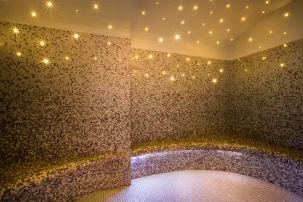 Interior of the Saint-Antoine hammam, with benches, mosaic walls and a starry ceiling.