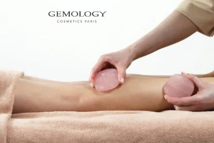 Close-up of the legs of a woman lying face down while a spa therapist performs a ritual body treatment.