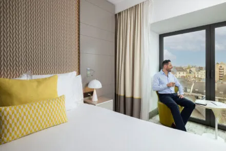Salon de la suite de l’hôtel avec canapé, fauteuils et table, aménagé pour une réunion professionnelle privatisée.